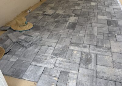 Workers installing paver deck around pool during renovation by Planet Pool Renovations in Orlando, FL