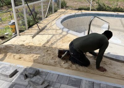 Paver installation around spa cutout during pool renovation by Planet Pool Renovations in Orlando, FL