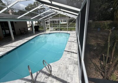 Renovated backyard pool with wood deck and American flag by Planet Pool Renovations in Orlando, FL