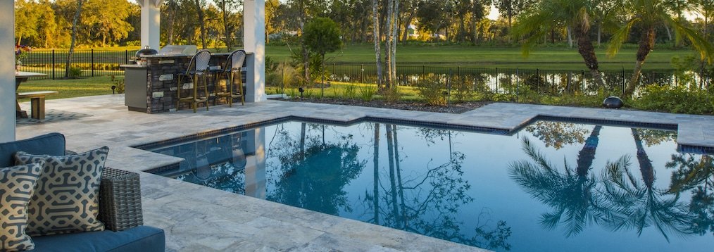 Outdoor kitchen and bar beside a pool