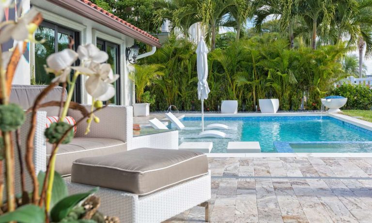 Poolside lounge furniture on a travertine deck